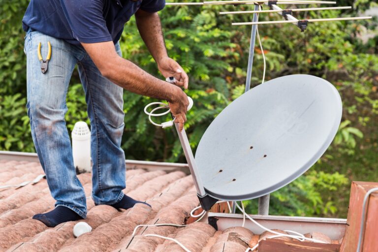 worker installing satellite dish and antenna on roof top 768x512