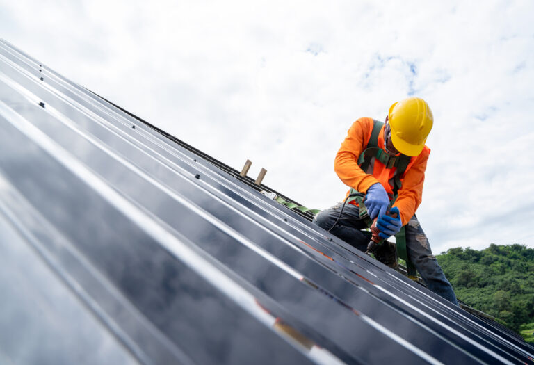 construction worker wearing safety equipment on roof 768x525